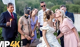 在热辣的户外婚礼游戏中，一位身材丰满的女子与戴着猎犬面具的新郎激情缠绵。